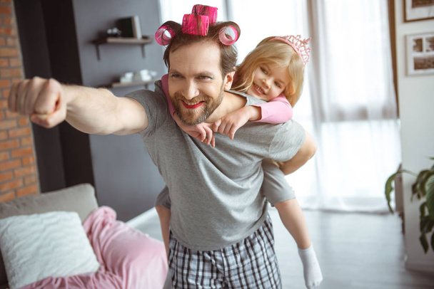 Cheerful parent playing in super hero with girl  - Foto, immagini