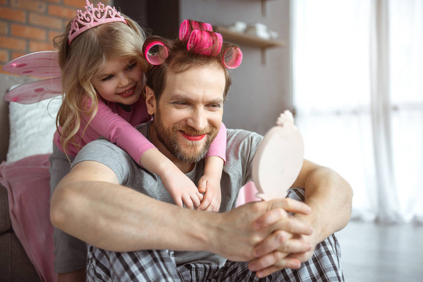 Cheerful father has make-up on face and hairdo - Foto, Imagem