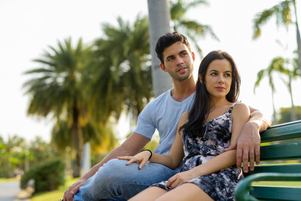 Young Hispanic couple relaxing in the park together - Fotografie, Obrázek