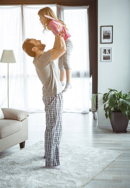 Joyful father playing with his kid at home  - Фото, изображение