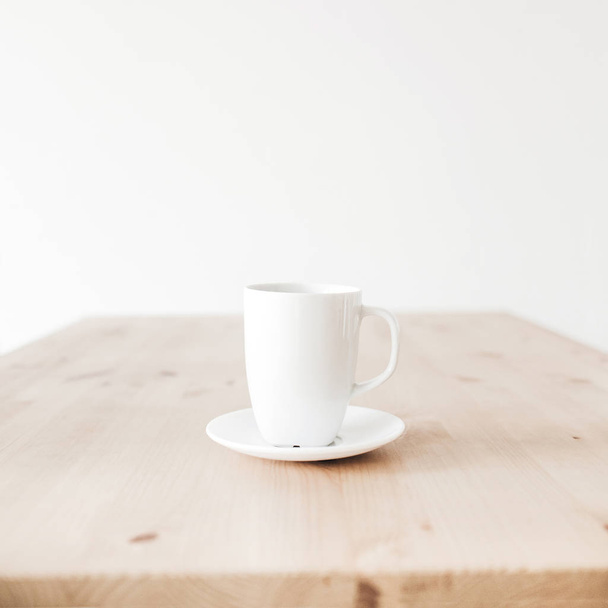 Cup of coffee on clean wooden table. Flat lay, top view minimalist background. - Foto, Imagen