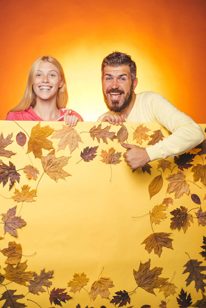 Autumn couple wearing in autumn clothes and looks very sensually. Joyful couple is happy with the last warm days of autumn. Bearded man in cap and blond girl with scarf are happy with autumn sales. - Foto, Imagem