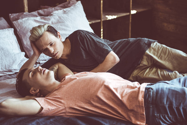 Young gay couple resting on bed at home - Foto, Imagen