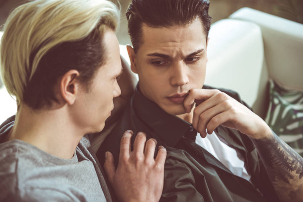 Loving boyfriend touching shoulder of sad young man - Zdjęcie, obraz