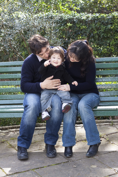 Asiatico madre caucasico padre e bambino su un parkbench
 - Foto, immagini