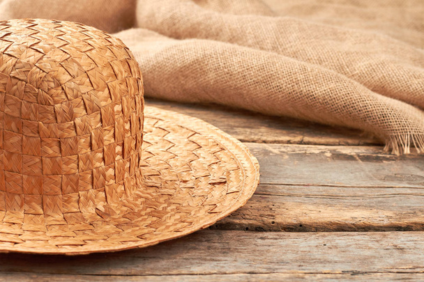 Ψάθινο καπέλο σε ρουστίκ ξύλινα φόντο. - Φωτογραφία, εικόνα