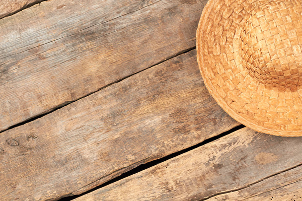 Vintage style straw hat on wooden background. - Foto, afbeelding