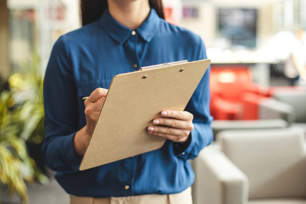 Female person holding brown folder with papers - Foto, Imagem