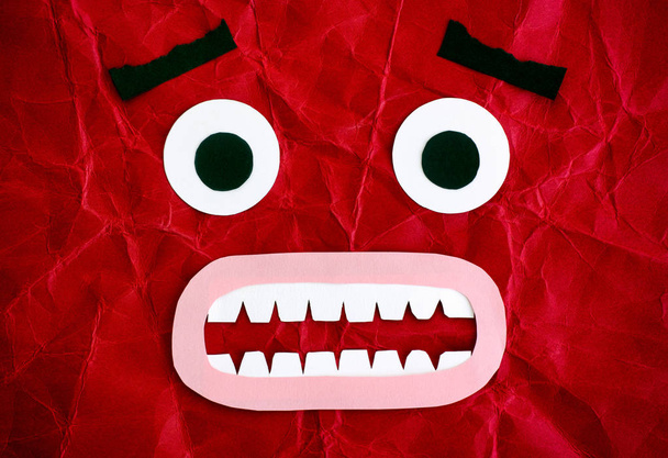 Scared character. Emotional face made from paper. Red background. - Foto, Imagem