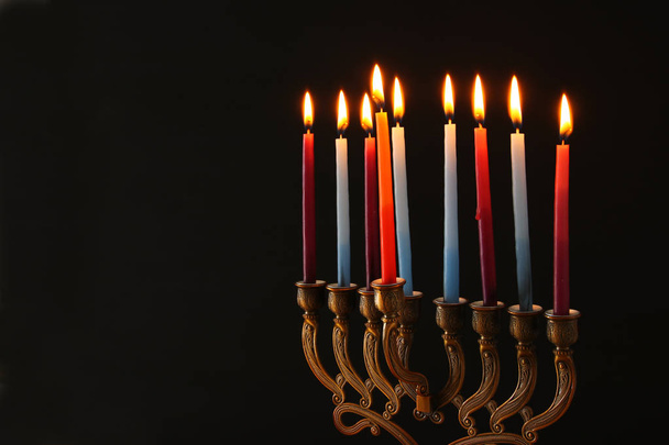 Low key Image of jewish holiday Hanukkah background with menorah (traditional candelabra) and burning candles. - Foto, Imagen