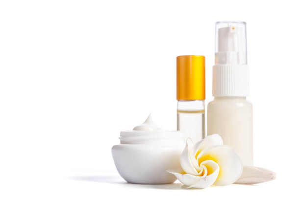 Beautiful flowers and bottles with natural skincare cream isolated on white background - Fotó, kép