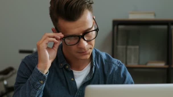 Portret młodego działalności człowieka w casual shirt pracę w laptopie w biura stylowe, uczucie anoying ból głowy. - Materiał filmowy, wideo