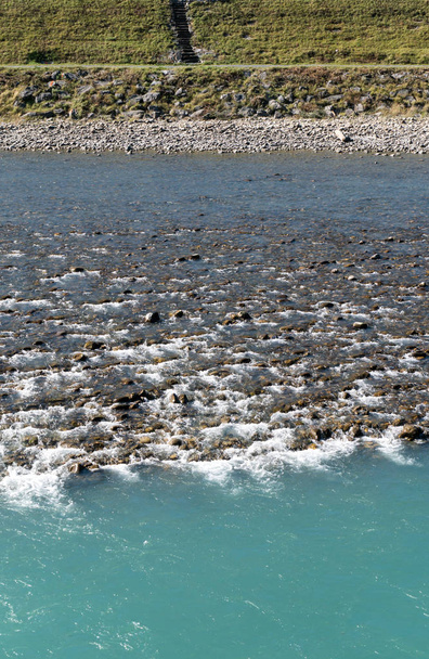 Rhine river with rocks and different color blue water in Switzerland near Maienfeld - Photo, Image