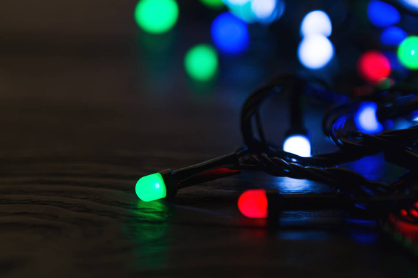 Luzes de Natal no fundo de madeira escura com espaço de cópia
 - Foto, Imagem