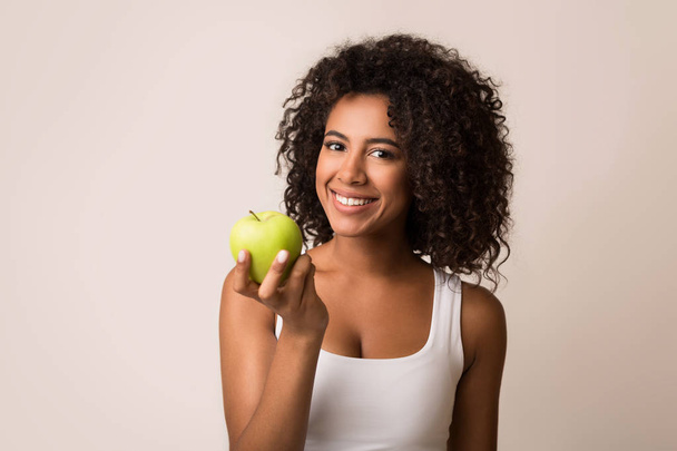 Uśmiechnięta kobieta ze zdrowymi zębami trzymająca zielone jabłko - Zdjęcie, obraz