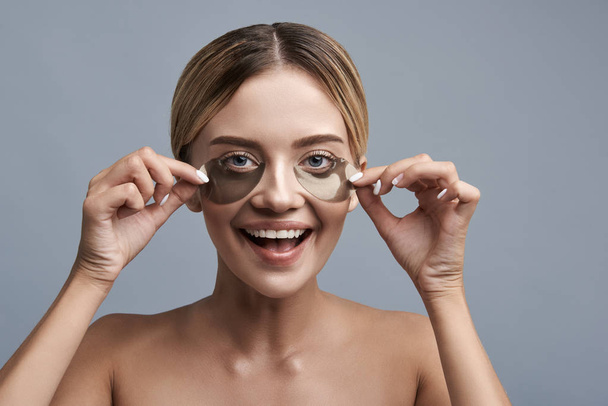 Emotional girl taking off eye patches and feeling excited - Fotoğraf, Görsel