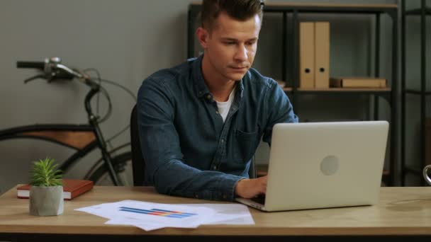 Attractive business man in casual shirt working in the laptop in the stylish office. - Séquence, vidéo