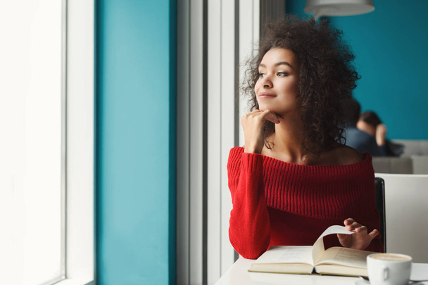 Réfléchie fille noire au café lecture d'un livre
 - Photo, image