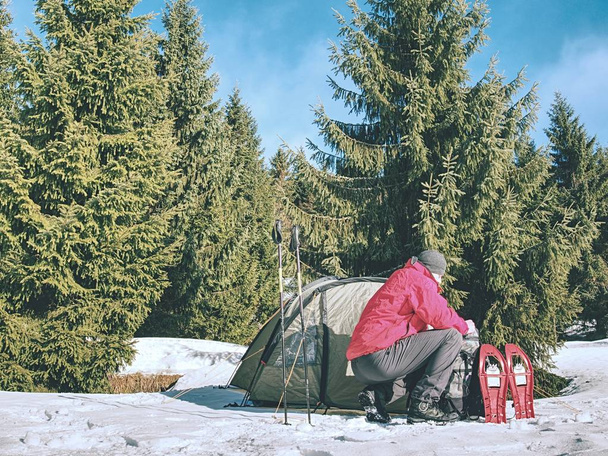 Kemping sátor téli erdőben. Hótalp trek-hegység beállítása egy sátorban a hóban. - Fotó, kép