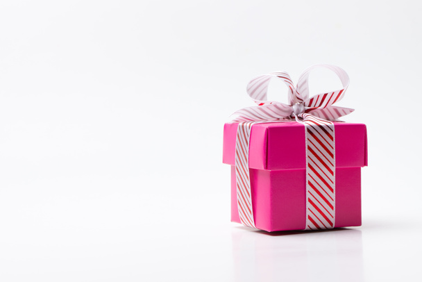 Pink gift box tied with white red stripe ribbon - Foto, afbeelding