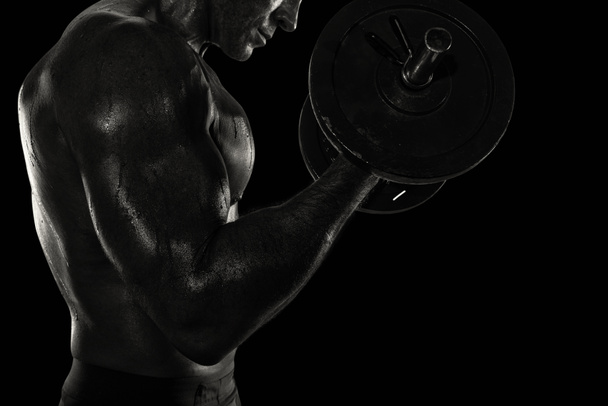 Atletische man opleiding biceps op de sportschool. zwart-wit effect - Foto, afbeelding