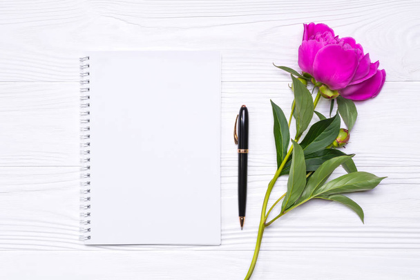 Blocco note vuoto con spazio per testo, penna e fiore di peonia su sfondo bianco
 - Foto, immagini