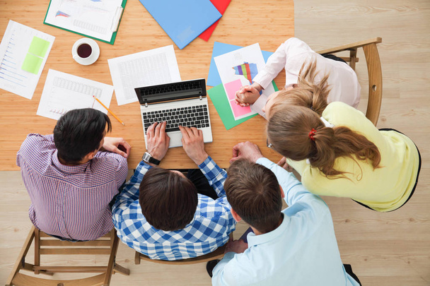 Встреча бизнес-команды, люди в повседневной одежде, работающие с финансовой статистикой в офисе - Фото, изображение
