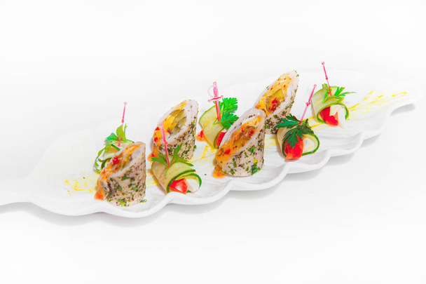 Vegetable rolls on a white plate. Cold snacks in the restaurant. Snack on skewers on a light background - Фото, изображение