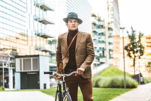 Young handsome man with casual clothes driving bycicle - Young student portrait, concepts about business, mobility and lifestyle - Photo, Image