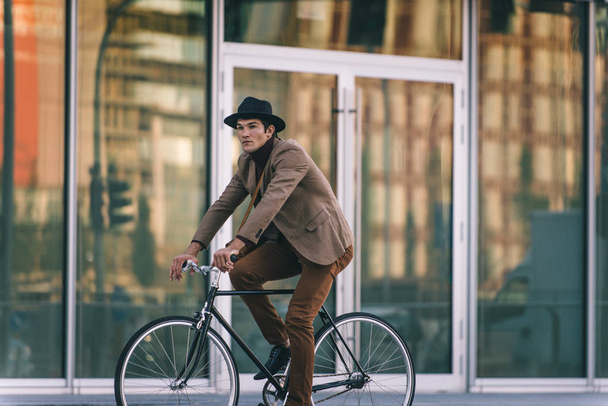 Young handsome man with casual clothes driving bycicle - Young student portrait, concepts about business, mobility and lifestyle - Foto, Imagen