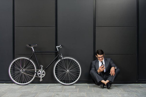 Young handsome man with business suit driving bycicle - Corporate businessman portrait, concepts about business, mobility and lifestyle - Foto, Bild