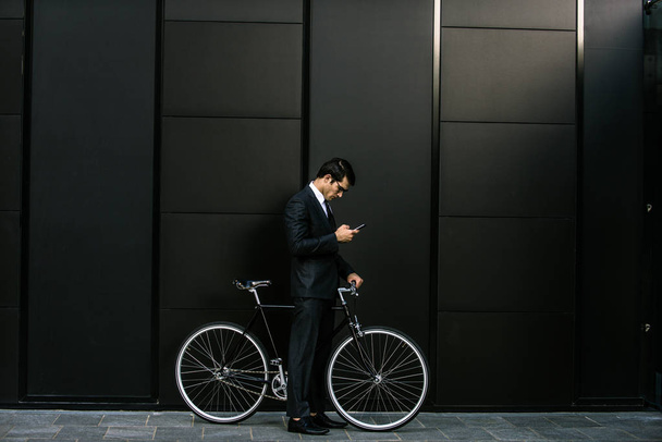 Young handsome man with business suit driving bycicle - Corporate businessman portrait, concepts about business, mobility and lifestyle - Φωτογραφία, εικόνα