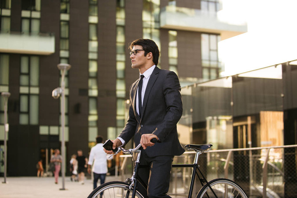Young handsome man with business suit driving bycicle - Corporate businessman portrait, concepts about business, mobility and lifestyle - Foto, Imagem