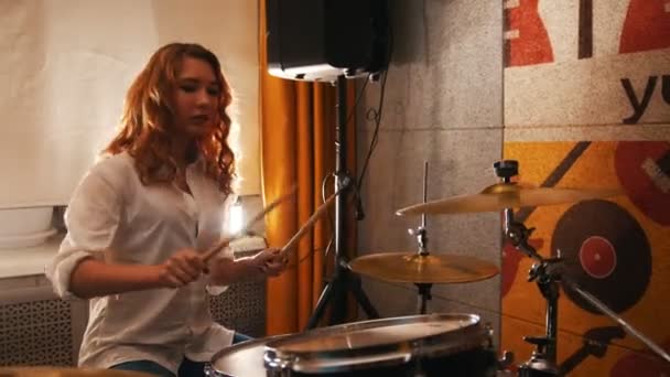 Wiederholung. nettes rothaariges Mädchen spielt Schlagzeug. Studiolights - Filmmaterial, Video