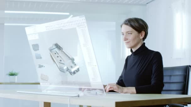 V blízké budoucnosti krásné ženské inženýr pracuje na svém počítači s průhledným displejem. To vytvoří složitý 3d Model. Kancelář je světlé a moderní. - Záběry, video