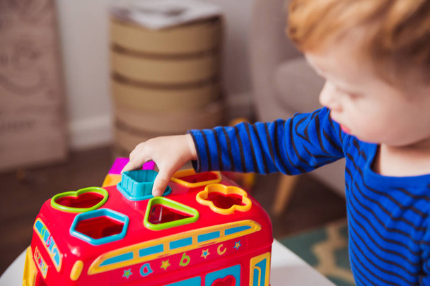 Portrait of little cute boy who playing with toys in the room - 写真・画像
