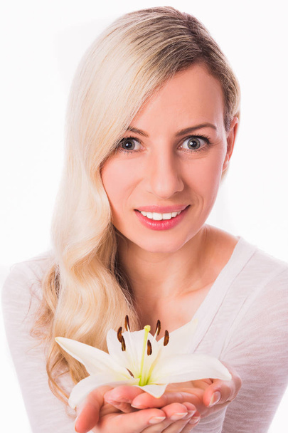 Portrait of young divine blonde woman who keeping flower lily in hands against the white background - Photo, image