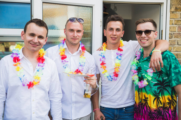 The young smiling friends standing in home party outdoors - Foto, Bild