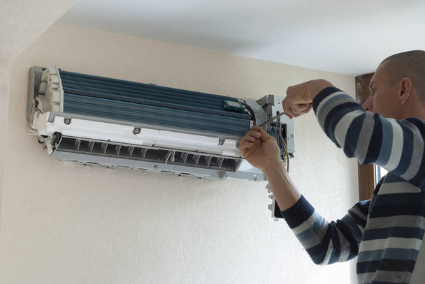 trabajador instala la unidad de aire acondicionado interior en la pared
 - Foto, imagen