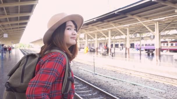 Yavaş hareket - tren için yaz aylarında seyahat etmek tren istasyonunda bekleyen mutlu Asyalı kadın. Seyahat Tayland kavramı. - Video, Çekim