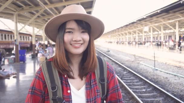Cámara lenta - Mujer asiática feliz esperando el tren en la estación de tren para viajar en verano. Viajes Tailandia concepto
. - Imágenes, Vídeo