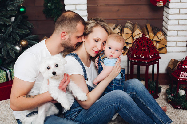 Positiivisuus perhe poseeraa yhdessä lähellä takka ja lahjoja jouluksi
 - Valokuva, kuva
