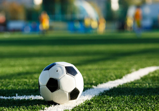 κλασικό μαύρο και άσπρο ποδόσφαιρο μπάλα για το πράσινο γρασίδι του πεδίου. Παιχνίδι ποδοσφαίρου, κατάρτιση, έννοια χόμπι. χώρο αντίγραφο  - Φωτογραφία, εικόνα