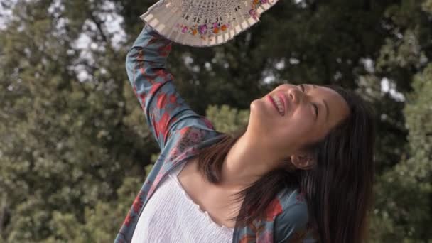 lato, ciepło, ochłodzić. młody Asian kobieta fan z a fan w The Park - Materiał filmowy, wideo