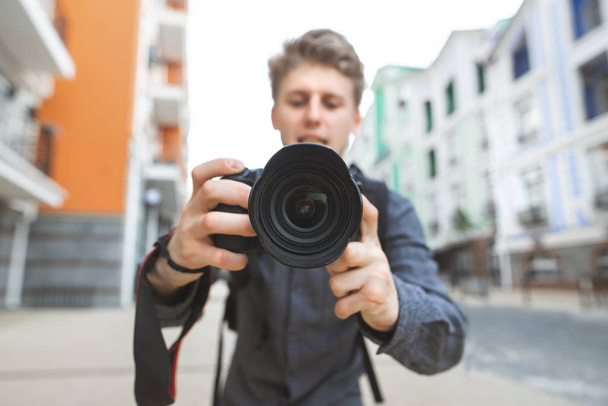 Camera in de handen van de fotograaf close-up en in focus. Fotograaf met een camera in zijn handen pikt op in de straten van de stad. Fotograaf Concept - Foto, afbeelding