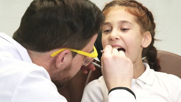 Egy figyelmes fogorvos azt vizsgálja, hogy a kis beteg - Fotó, kép