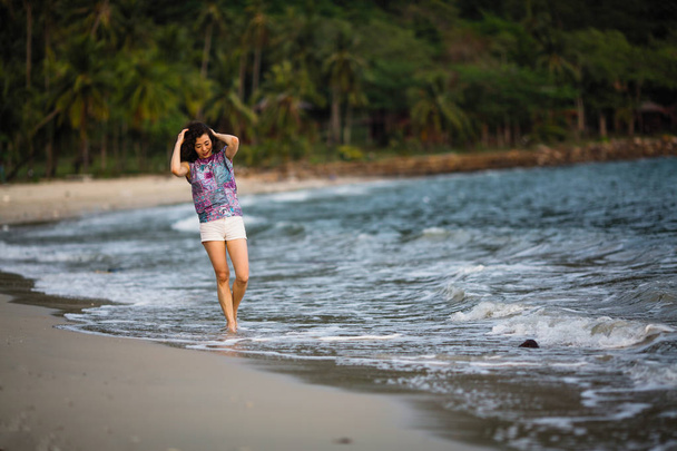 Jeune femme métisse marchant sur la plage de la mer
. - Photo, image