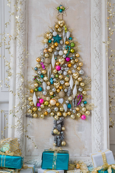 Hermoso salón interior decorado para Navidad. Gran marco de espejo con un árbol hecho de pelotas y juguetes - Foto, imagen