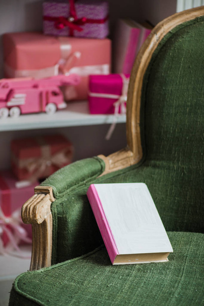 A casa para Navidad. Libro en el sillón y regalos el fondo
. - Foto, Imagen
