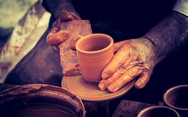 Potter`s hands shaping up the clay of the pot - Photo, Image